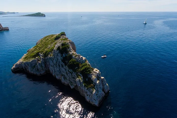 Luftaufnahme einer felsigen Insel und von Booten in der Adria.